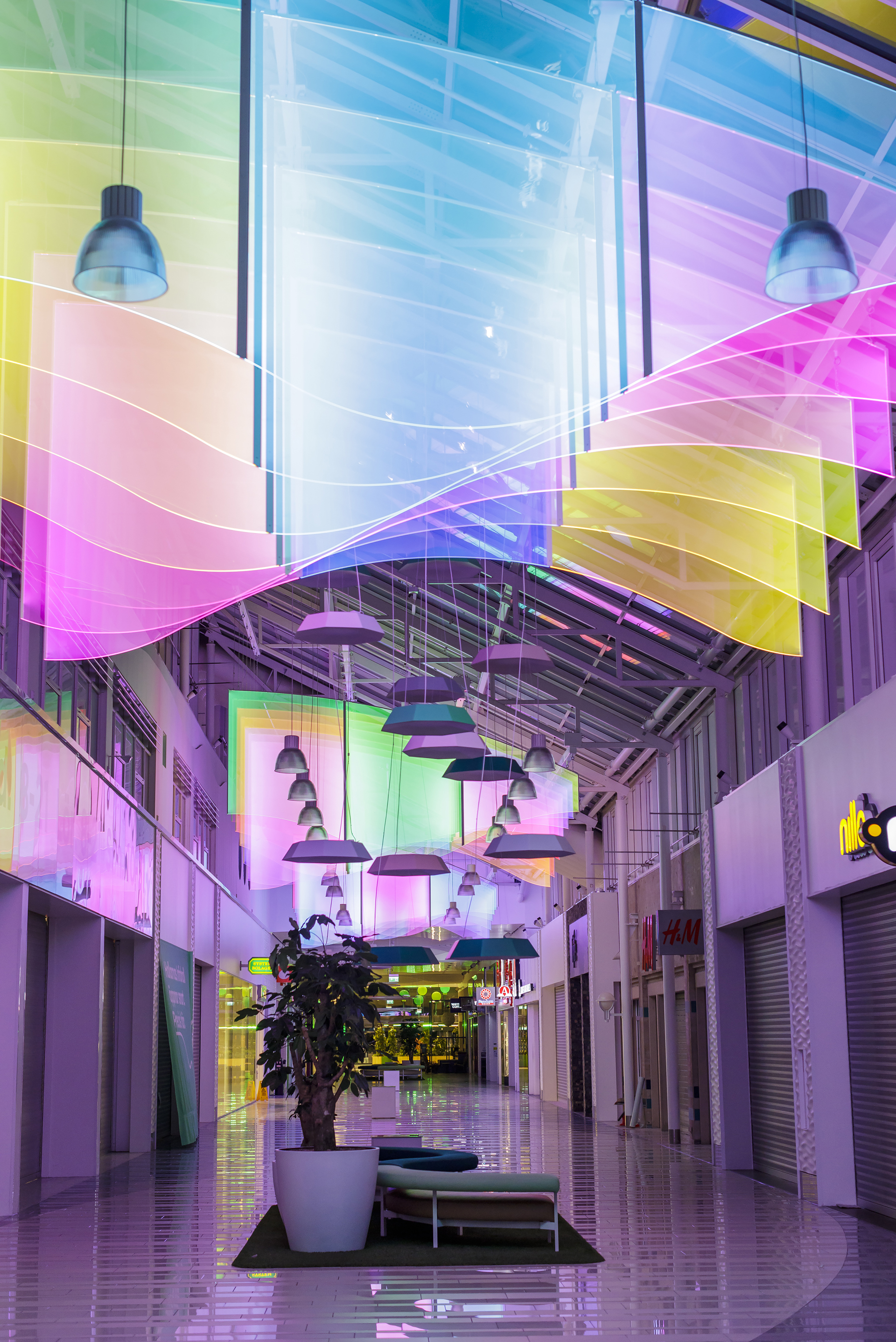 Bildet viser Hallarna kjøpesenter fra innsiden med takinnstallasjoner i alle regnbuens farger i taket.